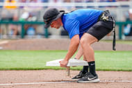 The Charles Schwab Field Omaha grounds crew pick up the bases during a rain delay.
